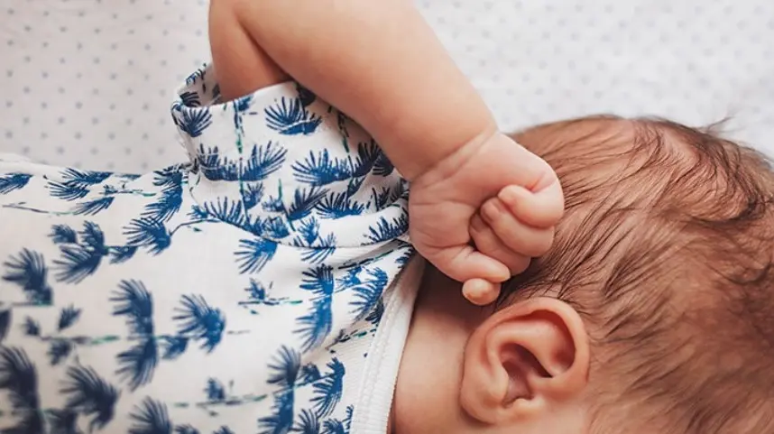 bébé entrain de se se frotter l'oreille