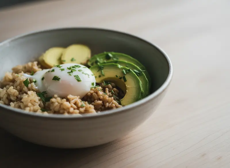 Gros plan sur une assiette composée d'aliments naturels et faciles à digérer : avocat, quinoa, légumes verts et saumon, symbolisant une nutrition d'éviction saine pour le microbiote féminin