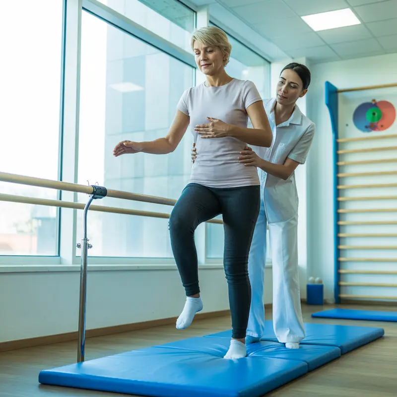 Séance de rééducation vestibulaire avec kinésithérapeute pour traiter les troubles de l'équilibre : patiente réalisant des exercices de stabilisation du regard et d'équilibration sous supervision professionnelle